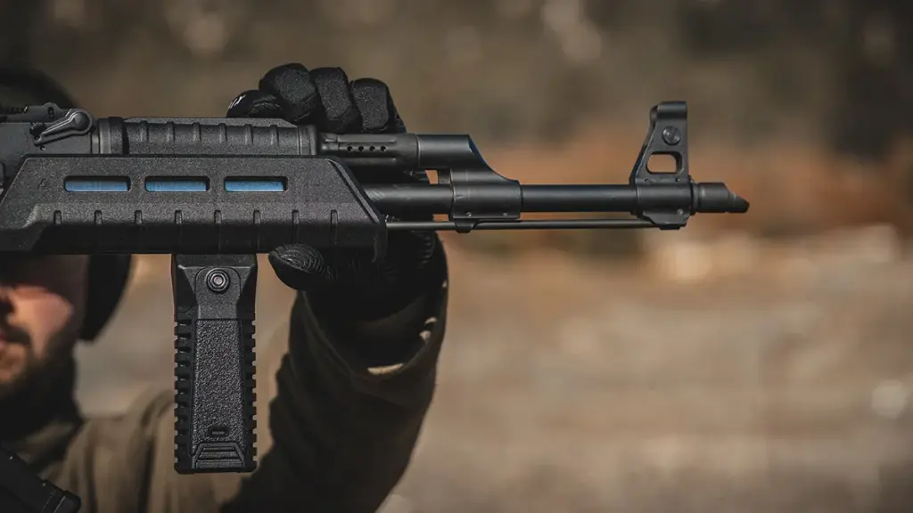 Operator handling an AK rifle fitted with M-LOK compatible accessories