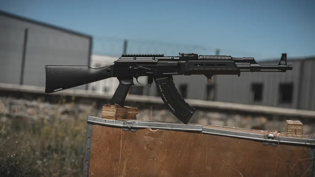 AK rifle with black polymer furniture resting on a wooden crate
