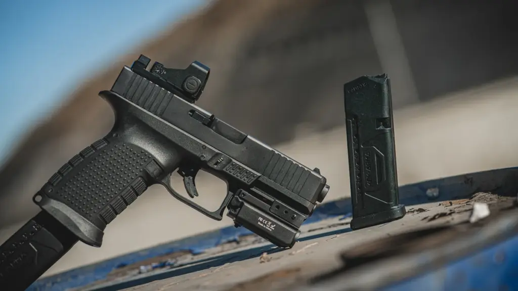 Pistol with a polymer frame, optic and spare magazine