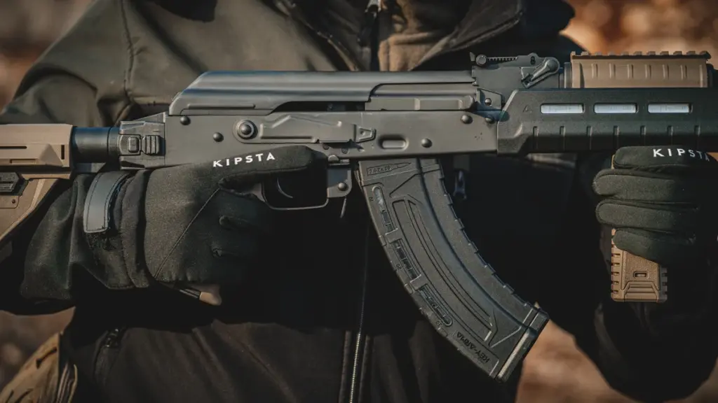 Operator holding an AK rifle with polymer furniture and magazine