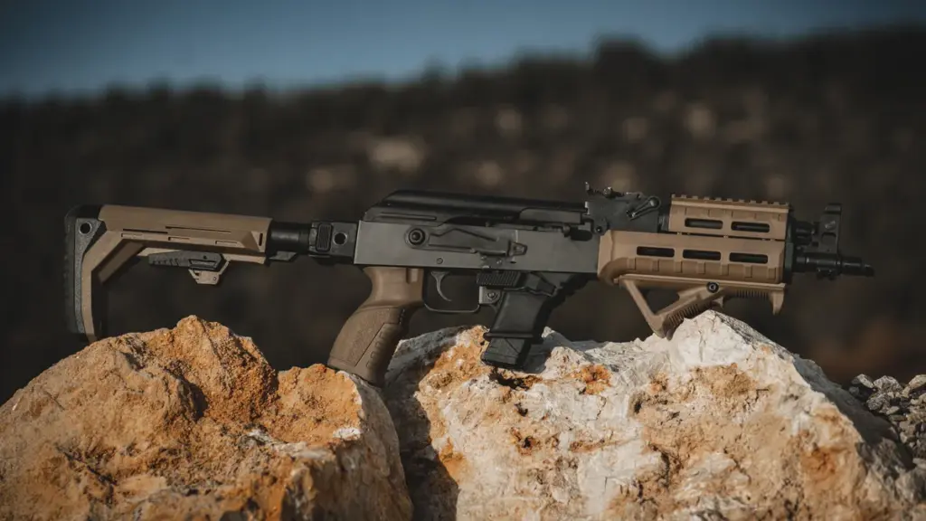 AK-pattern rifle with a full FDE polymer furniture set resting on rock
