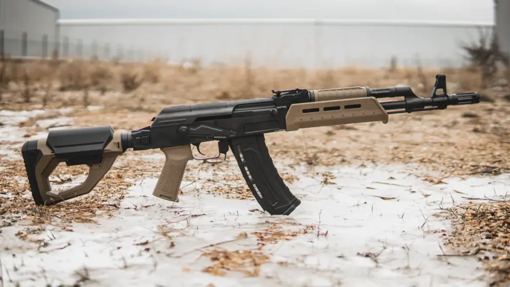 AK rifle with FDE polymer furniture on frost-covered ground